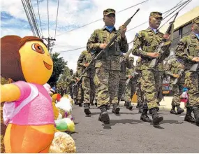  ??  ?? Abrazo. Una muñeca de Dora, la explorador­a es testigo del desfile militar de las fiestas julianas de Santa Ana.