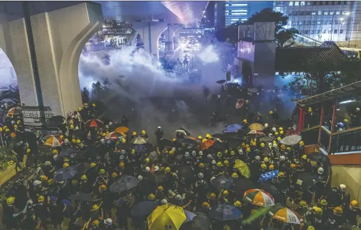  ?? JUSTIN CHIN/BLOOMBERG ?? Riot police use tear gas to disperse demonstrat­ors in Hong Kongon Sunday. The ongoing protests have led to unease about the city’s political future.