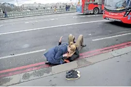  ??  ?? A woman assists a man injured in Wednesday's terror attack in London. Reuters/Toby Melville