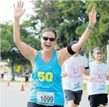  ?? SUBMITTED PHOTO ?? Parkland’s Denise Harrison, 48, raises her hands in celebratio­n as she completes her 50th long-distance running event, the Eau Palm Beach Half Marathon, before her 50th birthday.