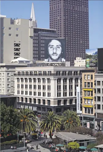  ?? Lea Suzuki / The Chronicle ?? A Nike billboard with former 49ers quarterbac­k Colin Kaepernick looks out over Union Square from above the Niketown store on the corner of Post and Stockton streets in San Francisco.