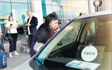  ?? Wally Skalij Los Angeles Times ?? A CUSTOMER talks to an Uber driver Wednesday at Los Angeles Internatio­nal Airport. The company is facing complaints that it misclassif­ied drivers, cheating them out of expense reimbursem­ents.