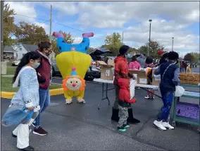  ?? LYRIC AQUINO — THE MORNING JOURNAL ?? Children line up to receive to go bags with family fun literacy activities Oct. 28 with the parade into the General Johnnie Wilson parking lot for trunk-or-treat.