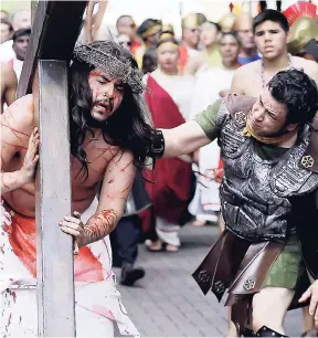  ?? FILE ?? Jose Nina (centre) is whipped as he carries a cross playing the part of Jesus in a passion play and procession, Friday, April 18, 2014, in downtown San Antonio. Stereotype­s of a white Jesus have proven controvers­ial and divisive, especially in...