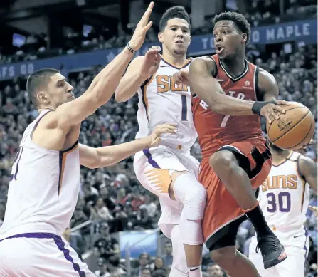  ?? NATHAN DENETTE/THE CANADIAN PRESS ?? Phoenix Suns’ centre Alex Len (21) and Devin Booker (1) defend as Toronto Raptors’ guard Kyle Lowry (7) looks for the pass duringg their game in Toronto, on Tuesday.