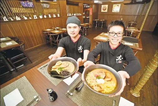  ?? Peter Hvizdak / Hearst Connecticu­t Media ?? Iishin Ramen Bar chef and co-owner Johnny Chen, left, holds Signature Iishin Ramen, and co-owner Penny Gao holds a bowl of Miso Ramen/Spicy Miso Ramen on Friday at the new ramen restaurant, the first in West Haven. Below, Gao serves a ramen bowl to Daniel Ampofo of West Haven.