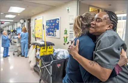  ?? Alexandra Wimley/Post-Gazette ?? Theresa Scheiffart­h, a nursing assistant at UPMC Shadyside, hugs Taunia Johnson of Stanton Heights as they meet in the hallway of the hospital. Ms. Johnson began working as a cleaner at the hospital in June 2017 after completing a training program at the Energy Innovation Center. “It was a great opportunit­y to open the door for me to do something different in life,” she said.