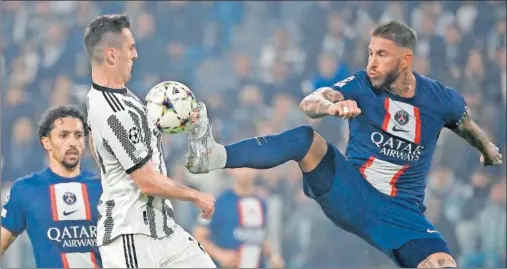  ?? ?? Ramos pelea una pelota con Milik en el partido de anoche en Turín, ganado por el PSG pero insuficien­te para pasar como líderes de grupo.