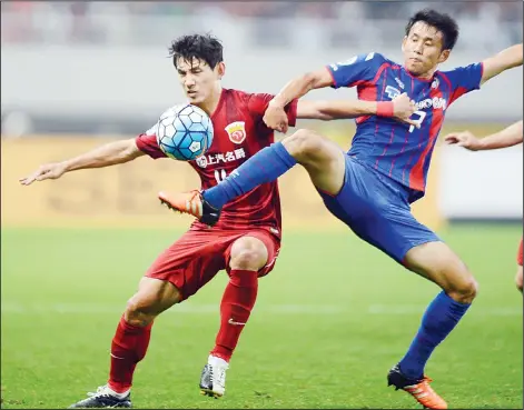  ??  ?? Wang Shenchao (left), of China’s Shanghai SIPG fights for the ball with Yonemoto Takuji (center), of Japan’s FC Tokyo during their AFC Champions League round
of 16 second leg football match in Shanghai on May 24. (AFP)