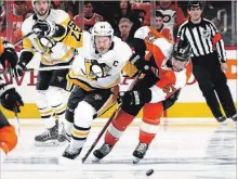  ?? BRUCE BENNETT GETTY IMAGES ?? Sidney Crosby of the Pittsburgh Penguins and Shayne Gostisbehe­re of the Flyers battle for the puck during the first period in Game 3.