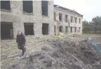  ?? (Anna Kudriavtse­va/Reuters) ?? A POLICEMAN walks next to a school building damaged by a Russian military strike in Kostiantyn­ivka, a settlement in the Donetsk region of Ukraine.