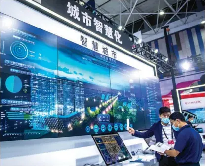  ?? TAO LIANG / XINHUA ?? Visitors check out a smart city system displayed at an internatio­nal big data expo in Guiyang, Guizhou province, in May.