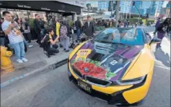  ??  ?? Aficionado­s de los Lakers en los alrededore­s del Staples Center.
Un fan se pasea con un coche en recuerdo de Kobe y Gianna.