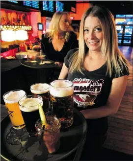  ??  ?? Chelsea Percival, a server at National Beer Hall, serves up an array of beers.