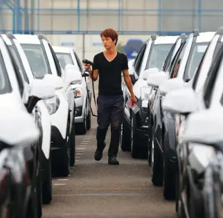  ??  ?? A worker checks cars in a yard of GM Korea’s Bupyeong plant. The automaker is deciding the fate of its local plants this week. (Reuters)