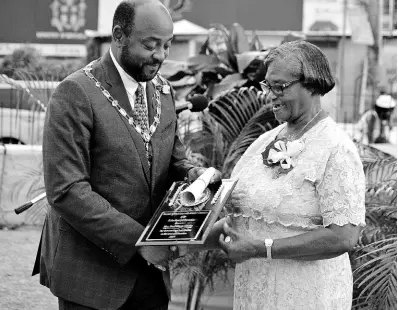  ??  ?? Buel Gloria Clarke collects her award from Mayor of St Ann’s Bay Michael Belnavis.