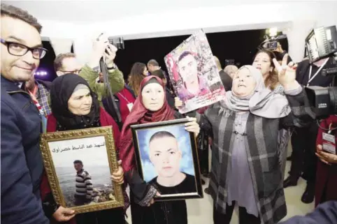  ??  ?? TUNIS: Tunisian mothers of a torture victims carry their sons’ portraits as they arrive for a hearing before the Truth and Dignity Commission (IVD) on Thursday.—AFP