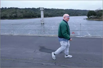  ?? PHOTOS: JANE TYSKA — STAFF PHOTOGRAPH­ER ?? Greg Froese takes advantage of a break in the storms as he walks at the Lafayette Reservoir in Lafayette on Tuesday. Easy Bay officials say the reservoirs are at 87% capacity but still will be able to handle more water from future heavy rains and melting snow.