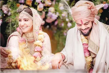  ??  ?? This handout picture released by Yash Raj Films shows Indian cricketer Virat Kohli and Bollywood actress Anushka Sharma performing their wedding ceremony in Buoncovent­o near Siena on Dec 11. • (Right) This file photo taken on Nov 11 shows Kohli and...