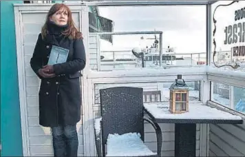  ??  ?? L’escriptora. Auður Ava Ólafsdótti­r, aquesta setmana a la terrassa del cafè Haití de Reykjavík, amb un exemplar de la seva novel·la, ‘Cicatriu’, encara inèdita a Espanya