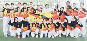  ??  ?? Mahyan presents the state colours to Abdillah (sixth left) at the Sarawak Lawn Bowls Arena in Petra Jaya on Tuesday.