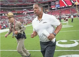 ??  ?? Cardinals head coach Steve Wilks runs off the field after losing 24-6 to the Washington Redskins at State Farm Stadium in Glendale.