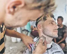  ??  ?? A barber cuts a client beard in a barbershop of Havana. More and more young Cubans have a beard because of an internatio­nal trend that came late to the island, 60 years after Fidel Castro and his ‘bearded’ rebels shocked the world with their triumphant revolution.