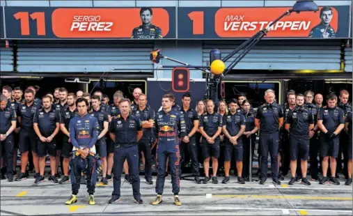  ?? ?? El equipo Red Bull guarda un minuto de silencio frente a su garaje en Monza en honor a la Reina Isabel II.