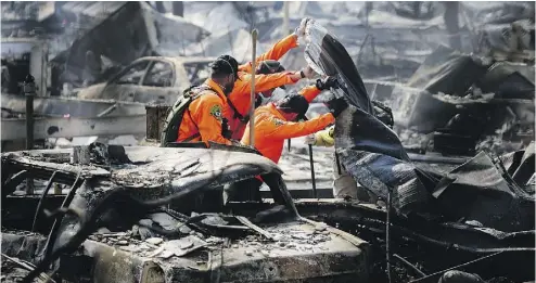  ?? ELIJAH NOUVELAGE / GETTY IMAGES ?? Search and rescue workers look for bodies in the Journey’s End Mobile Home park in Santa Rosa, Calif., on Friday. Thirty-five people have died in wildfires that have burned tens of thousands of acres in Northern California.