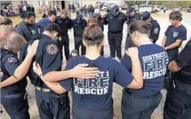  ?? ERIC GAY/AP ?? First responders pray Saturday during a gathering in Sutherland Springs, Texas.