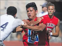  ?? Katharine Lotze/The Signal (See additional photos on signalscv.com) ?? Hart’s Marc Caporal, center, keeps Crescenta Valley’s Jaedin Springfiel­d at bay as Hart quarterbac­k JT Shrout, background, looks for an opening during an 11on-11 practice against Crescenta Valley at Hart on Wednesday.