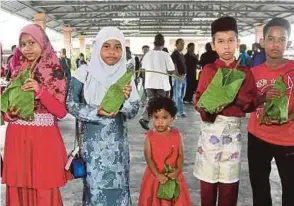  ?? (Foto Amran Yahya/bh) ?? Daun pokok tin dijadikan bungkusan daging korban yang diagihkan kepada penduduk sekitar Masjid Kariah Desa Anggerik, Kuala Pilah.