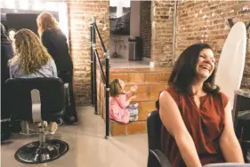  ?? ALEX WROBLEWSKI/THE ASSOCIATED PRESS ?? Katie Driscoll, right, and her 8-year-old daughter, Grace, center, who has Down syndrome, prepare for a photo spread in Women’s Health Magazine featuring mothers and daughters.