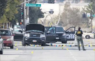  ?? Gina Ferazzi Los Angeles Times ?? SAN BERNARDINO sheriff ’s deputies at the scene where two shooters were killed in a gun battle with police. The assailants in the December attack used AR-15-style weapons to kill 14 people and wound 22 others.