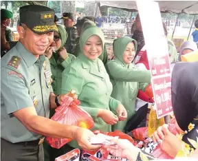  ?? AHMAD DIDIN/JAWA POS ?? SEDIA ANEKA SEMBAKO: Puluhan warga Surabaya berdesakan untuk mengantre sembako murah pada acara bazar di Lapangan Kodam V/ Brawijaya (foto atas). Pangdam V/Brawijaya Mayjen TNI Arif Rahman beserta istri, Mia Kusmiati Arif Rahman, melayani pembeli.