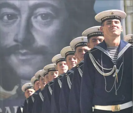  ?? Associated Press ?? Navy school cadets march during a parade devoted to City Day celebratio­n in St. Petersburg. A portrait of Peter the Great, a Russian emperor and founder of the city, is in the background.