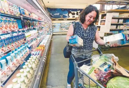  ?? Paul Aiken, Daily Camera ?? Tracy Eliasson places cartons of almond milk in her cart at Alfalfa’s Market in Boulder this month. The U.S. Food and Drug Administra­tion is considerin­g a crackdown on plant-based beverages labeled as milk. Other countries, such as Canada, also define milk as coming from a cow.