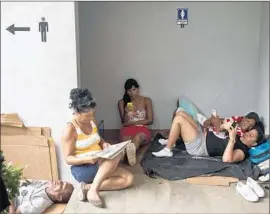  ?? Esteban Felix
Associated Press ?? CUBAN MIGRANTS check their cellphones at a border control building in Penas Blancas, Costa Rica. Cubans face much risk in the northward migration.