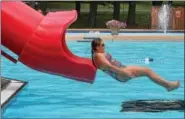  ?? DIGITAL FIRST MEDIA FILE PHOTO ?? Victoria Keener,13, plunges into the pool from a tubed sliding board at the North End Swim Club in Pottstown.