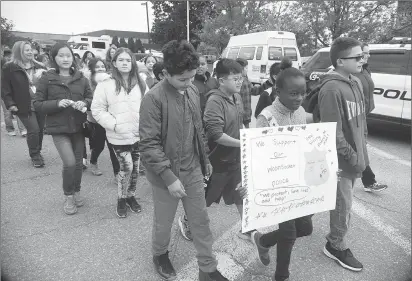  ?? Ernest A. Brown photo ?? Woonsocket students take part in the opening leg of the nationwide COPSWalk Tuesday morning, carrying signs in support of the Woonsocket Police Department.