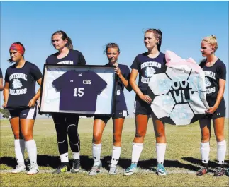  ?? Rachel Aston ?? Las Vegas Review-journal @rookie__rae Members of Centennial High School’s girls soccer team hold Brooke Hawley’s No. 15 jersey during a ceremony Wednesday before a game against Palo Verde. Hawley died in a car crash in March.