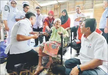  ?? — Bernama photo ?? Hilmi (right) talking to Minah Mat Pono, 97, during the Visit by Trainee Paramedics to Villages programme (Ziarah Kasih Sayang Pelatih Paramedik Masuk Kampung) and Food Fit Fun Fair in Sungai Sumun.