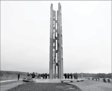  ?? AP PHOTO/KEITH SRAKOCIC, POOL ?? PEOPLE ATTENDING THE DEDICATION STAND AROUND THE 93-FOOT TALL TOWER OF VOICES on Sunday at the Flight 93 National Memorial in Shanksvill­e, Pa. The tower contains 40 wind chimes representi­ng the 40 people who perished in the crash of Flight 93 in the terrorist attacks of Sept. 11, 2001.