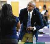  ?? KENT D. JOHNSON / AJC ?? Dr. Rodney Swanson, principal of Arabia Mountain High School, talks with a prospectiv­e candidate as teachers interview with several Region 4 schools during a job fair in DeKalb County.