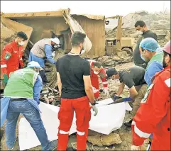  ??  ?? Their hour of trial: Young Lebanese aid workers rush to the rescue amid the ruins left by this week’s massive explosions in the capital, Beirut.