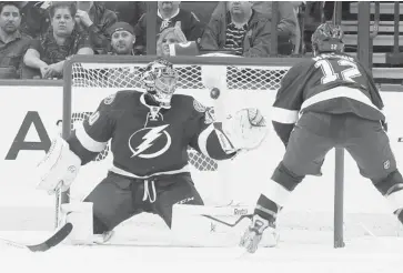  ?? CHRIS O’MEARA/THE ASSOCIATED PRESS ?? Tampa Bay Lightning goalie Ben Bishop reaches for a shot as left wing Ryan Malone moves in to help during the second period of an NHL hockey game against the Anaheim Ducks Thursday in TAMPA, Florida