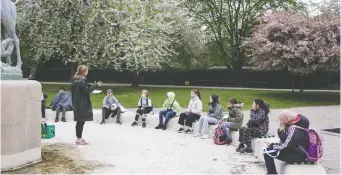  ?? THIBAULT SAVARY/AFP VIA GETTY IMAGES ?? Teacher Marie Kaas-Larsen works with Norrebro Park primary school pupils in a park in Copenhagen, Denmark. Classes in that country are being held outside as much as possible.