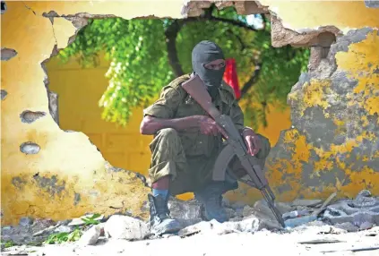  ?? A Somali soldier guards the site where Al Shabab militants carried out a suicide attack against a military intelligen­ce base in Mogadishu yesterday. The militants set off a car bomb before attempting to storm the building, security officials said.
Mohamm ??