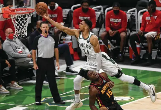  ?? Stacy Revere / Getty Images ?? Giannis Antetokoun­mpo’s bucket over Clint Capela in Game 2 on Friday brought back memories of an iconic play by another NBA great, Michael Jordan.