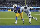  ?? MARCIO JOSE SANCHEZ — THE ASSOCIATED PRESS ?? Los Angeles Chargers running back Austin Ekeler scores a touchdown as Las Vegas Raiders outside linebacker K.J. Wright defends during the first half of an NFL football game Monday in Inglewood.